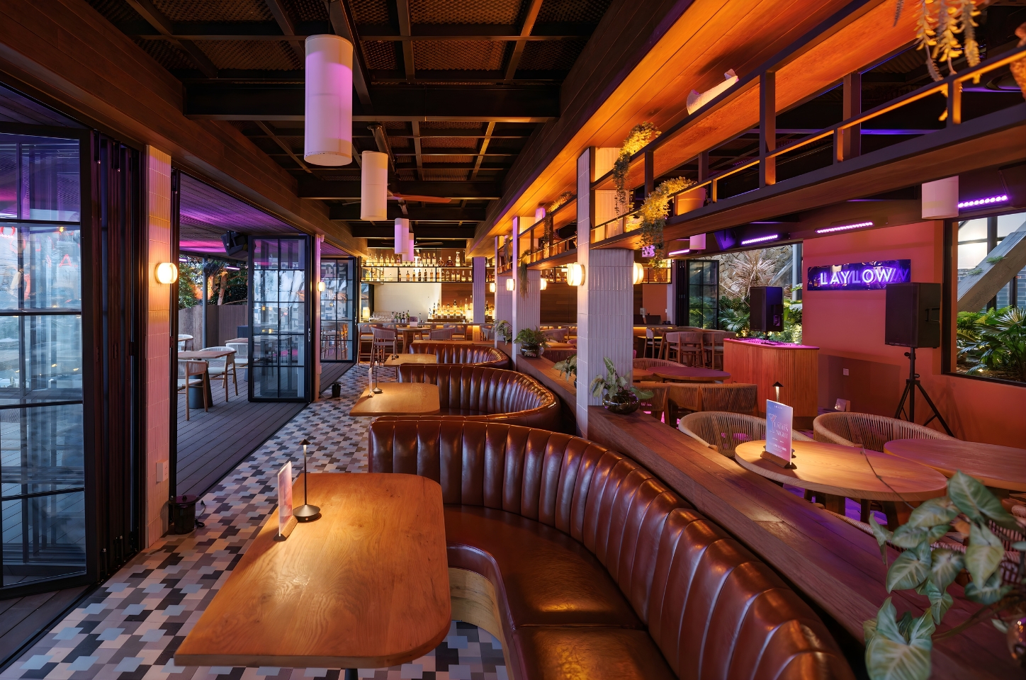 Không gian dining ngoài trời tại Laylow Phú Quốc buổi chiều, khách trò chuyện nhẹ nhàng trong nền nhạc với mức âm lượng dễ chịu