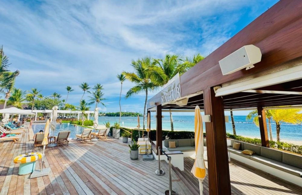 Hệ thống loa coaxial L-Acoustics X Series lắp đặt kín đáo tại beach club ven biển cao cấp, thiết kế âm thanh đa zone cho không gian nghỉ dưỡng