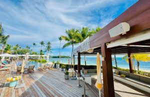 Hệ thống loa coaxial L-Acoustics X Series lắp đặt kín đáo tại beach club ven biển cao cấp, thiết kế âm thanh đa zone cho không gian nghỉ dưỡng